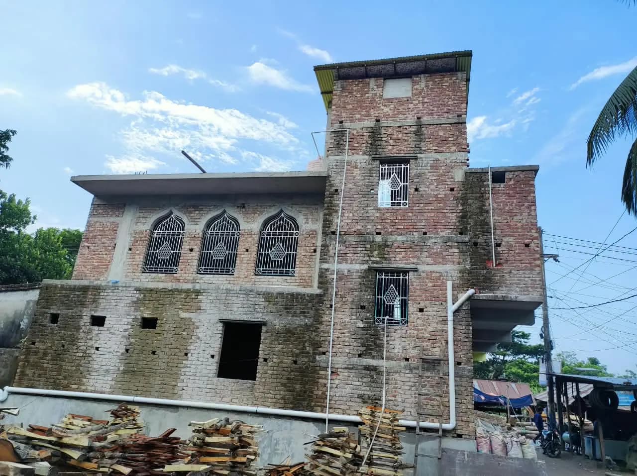 বাইতুল মামুর জামে মসজিদের বাইরের দৃশ্য — খিলানযুক্ত জানালা ও পাশের টাওয়ার