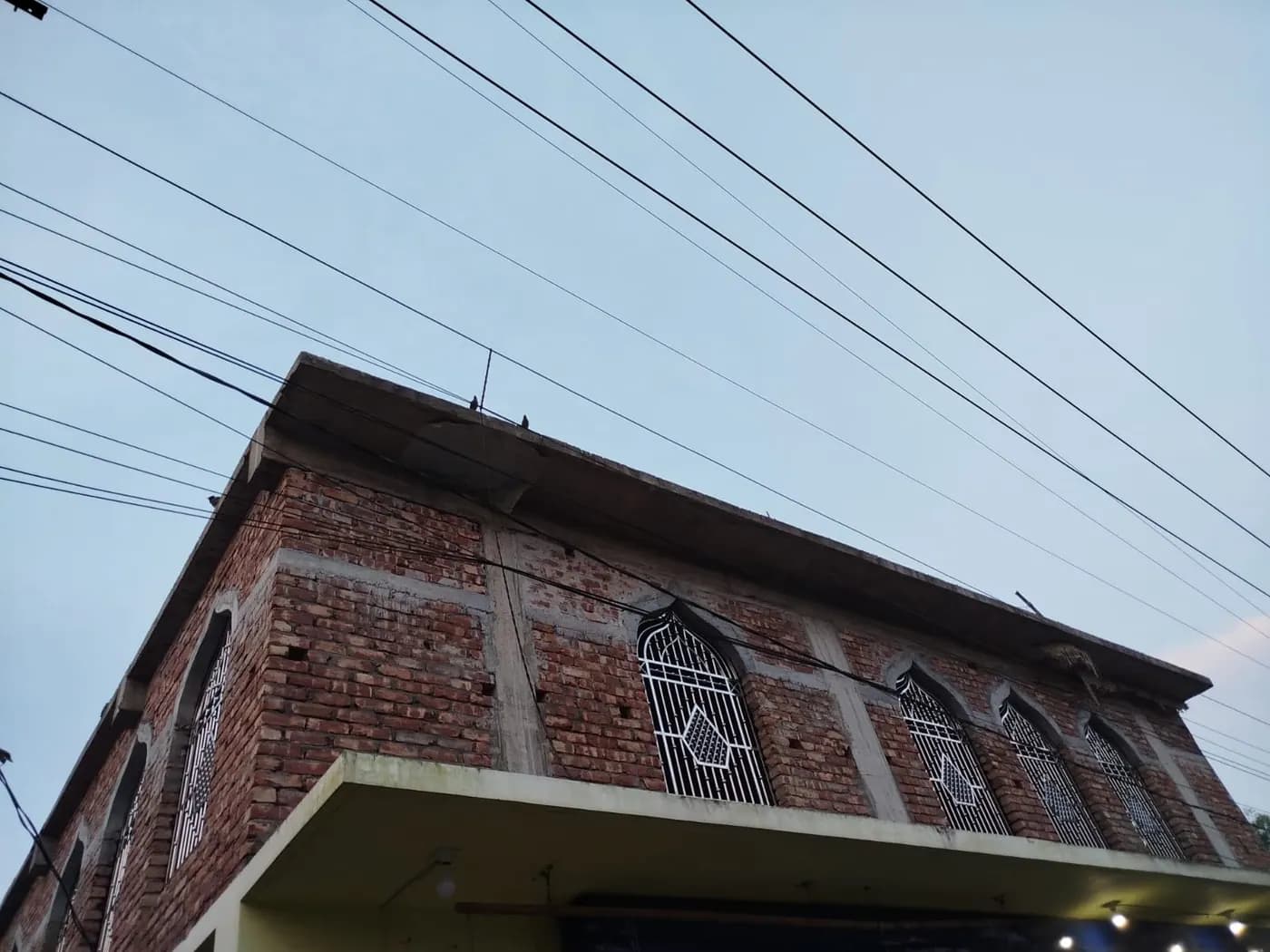 উপরতলার খিলানযুক্ত জানালা ও ধাতব গ্রিলের কাছাকাছি দৃশ্য